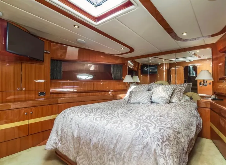 Yacht Photos Pics Luxurious bedroom interior of a 2005 Johnson 70 yacht with elegant wood finish.