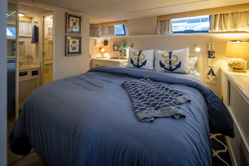 Graceful Spirit Yacht Photos Pics Cozy bedroom in 1990 Tollycraft 44 Cockpit Motor Yacht with nautical decor and soft lighting.