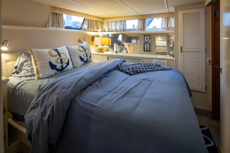 Graceful Spirit Yacht Photos Pics Cozy bedroom in 1990 Tollycraft 44 Cockpit Motor Yacht with nautical-themed decor.