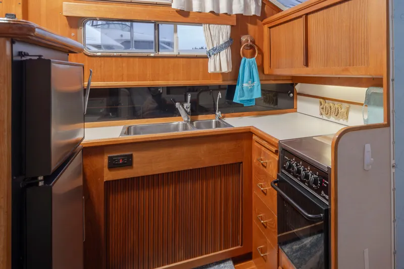 Graceful Spirit Yacht Photos Pics 1990 Tollycraft 44 Cockpit Motor Yacht kitchen with wood cabinetry and modern appliances.