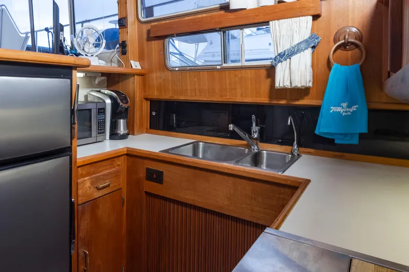 Graceful Spirit Yacht Photos Pics 1990 Tollycraft 44 Cockpit Motor Yacht kitchen with wood cabinetry, stainless steel appliances, and dual sink.