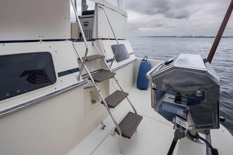 Graceful Spirit Yacht Photos Pics 1990 Tollycraft 44 Cockpit Motor Yacht deck with stairs and grill, overlooking calm waters.