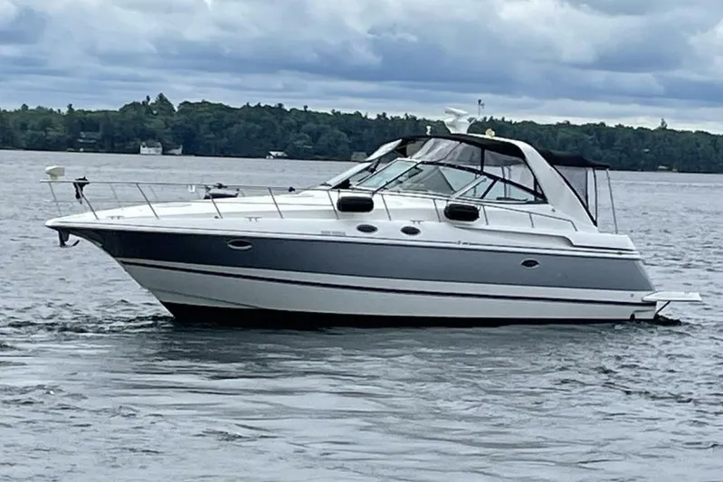  Yacht Photos Pics 2001 Cruisers Yachts 3870 on a lake with cloudy skies in the background.