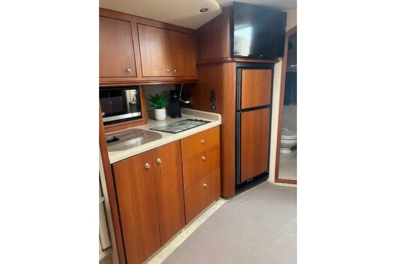  Yacht Photos Pics 2001 Cruisers Yachts 3870 interior kitchen with wood cabinets and modern appliances.