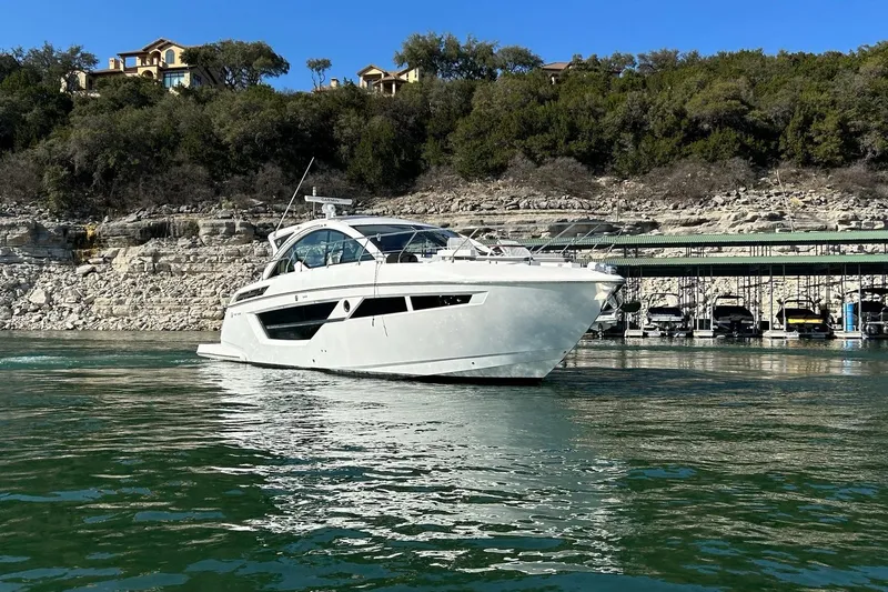 2021 Cruisers Yachts 50 Cantius Yacht Photos Pics 2021 Cruisers Yachts 50 Cantius on serene water near rocky shoreline.