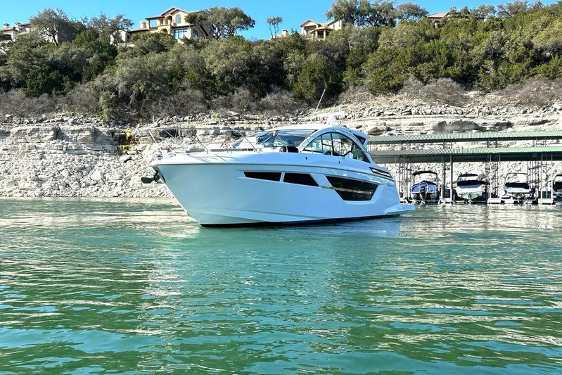 2021 Cruisers Yachts 50 Cantius Yacht Photos Pics 2021 Cruisers Yachts 50 Cantius on serene water near rocky shoreline.
