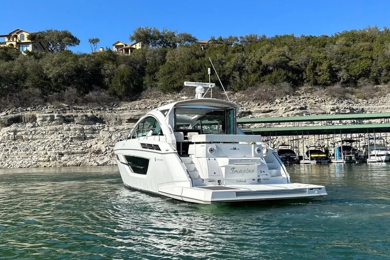 2021 Cruisers Yachts 50 Cantius Yacht Photos Pics 2021 Cruisers Yachts 50 Cantius on scenic lake with rocky shoreline backdrop.