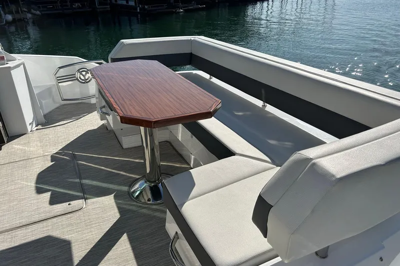 2021 Cruisers Yachts 50 Cantius Yacht Photos Pics Luxury seating area on 2021 Cruisers Yachts 50 Cantius, featuring elegant wood table.