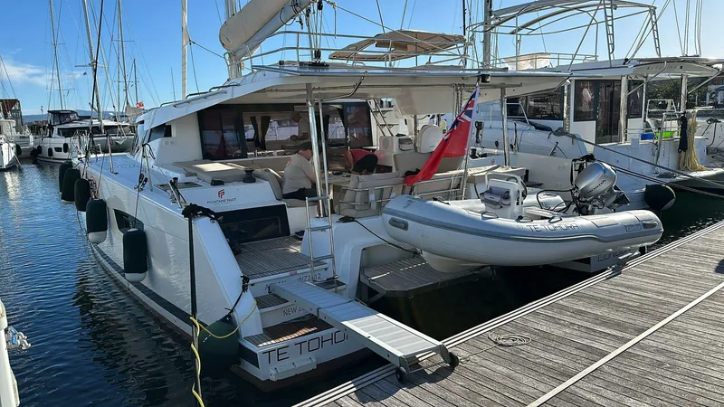 Elba 45 Yacht Photos Pics 2021 Fountaine Pajot Catamaran Elba 45 docked with dinghy, marina setting.