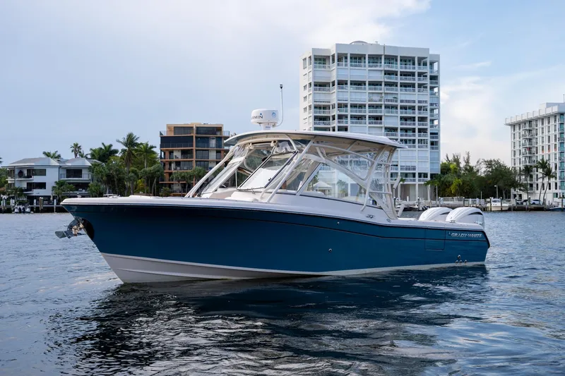  Yacht Photos Pics 2022 Grady-White Freedom 285 boat on water with modern buildings in background.