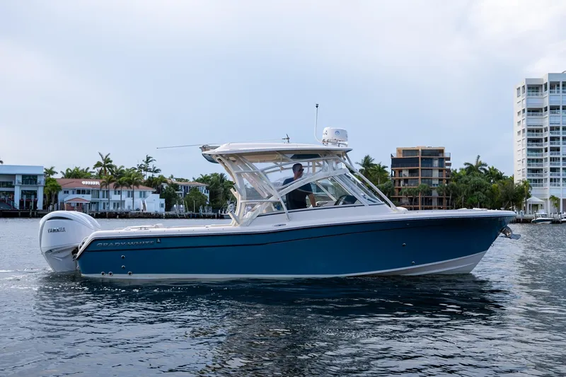  Yacht Photos Pics 2022 Grady-White Freedom 285 boat cruising on water near waterfront buildings.