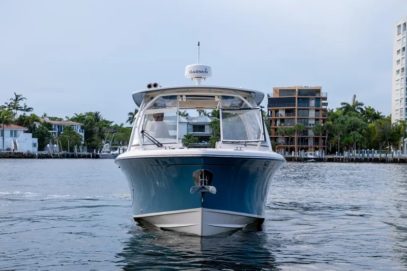  Yacht Photos Pics 2022 Grady-White Freedom 285 boat on water, with waterfront buildings in the background.