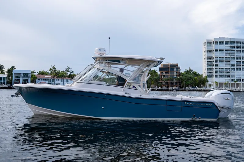  Yacht Photos Pics 2022 Grady-White Freedom 285 boat on water, with modern buildings in the background.