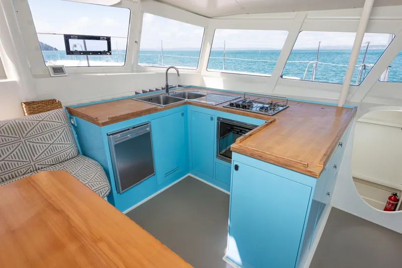 Diversion Yacht Photos Pics Modern kitchen interior on 2015 Custom Mcat 52 yacht with blue cabinets and ocean view.