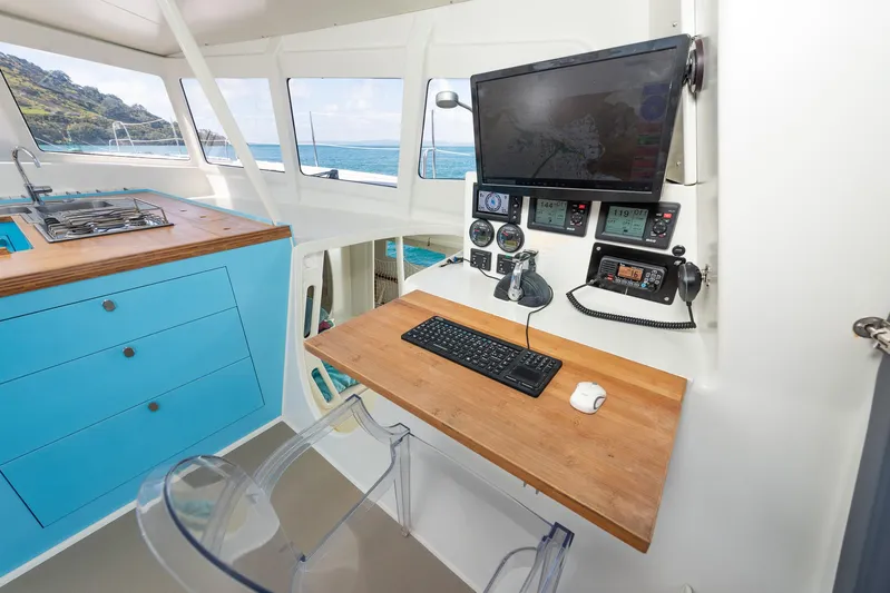 Diversion Yacht Photos Pics Modern boat interior with navigation equipment, blue cabinetry, and ocean view. Custom Mcat 52, 2015.