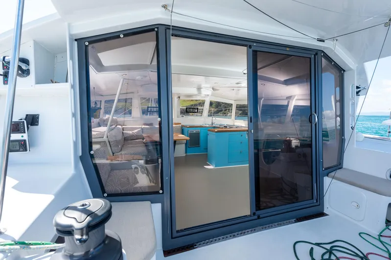 Diversion Yacht Photos Pics Modern yacht interior with blue cabinetry, viewed through glass doors on a Custom Mcat 52, 2015 model.