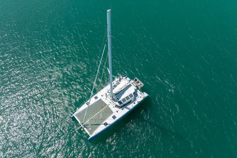 Diversion Yacht Photos Pics Aerial view of 2015 Custom Mcat 52 catamaran sailing on turquoise water.
