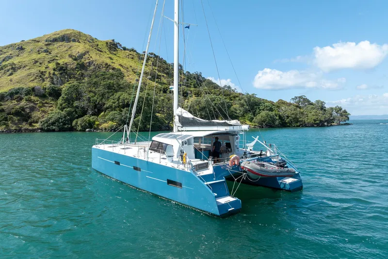 Diversion Yacht Photos Pics Custom Mcat 52 catamaran sailing near lush island, clear blue water, sunny day, 2015 model.