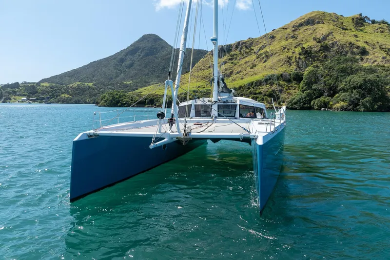 Diversion Yacht Photos Pics Custom Mcat 52 catamaran sailing in scenic bay with lush green hills, 2015 model.