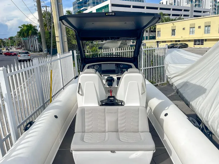  Yacht Photos Pics 2025 Ribco Venom 30 boat interior with modern seating and controls, docked in urban setting.