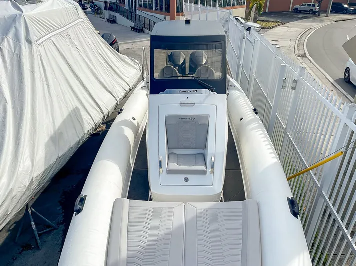  Yacht Photos Pics 2025 Ribco Venom 30 boat docked, featuring sleek design and spacious seating.
