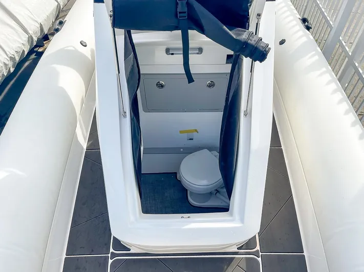  Yacht Photos Pics 2025 Ribco Venom 30 boat interior with compact toilet and seating.