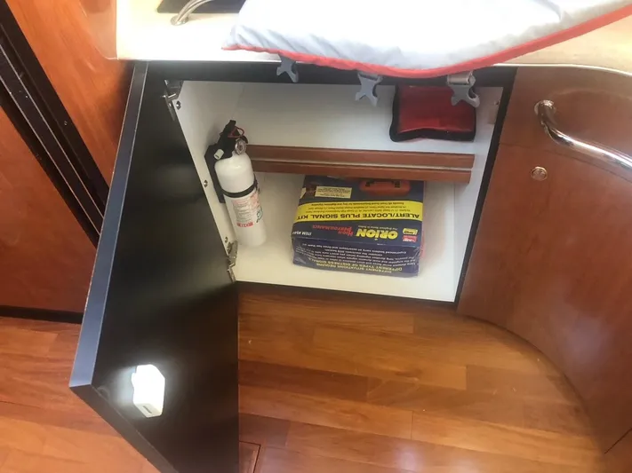 Hat Trick Yacht Photos Pics Open cabinet on 2003 Sea Ray 400 Sedan Bridge with fire extinguisher and cleaning supplies.
