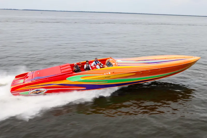  Yacht Photos Pics 2005 Outerlimits 51 Sport Yacht speeding on open water, featuring vibrant, colorful design.