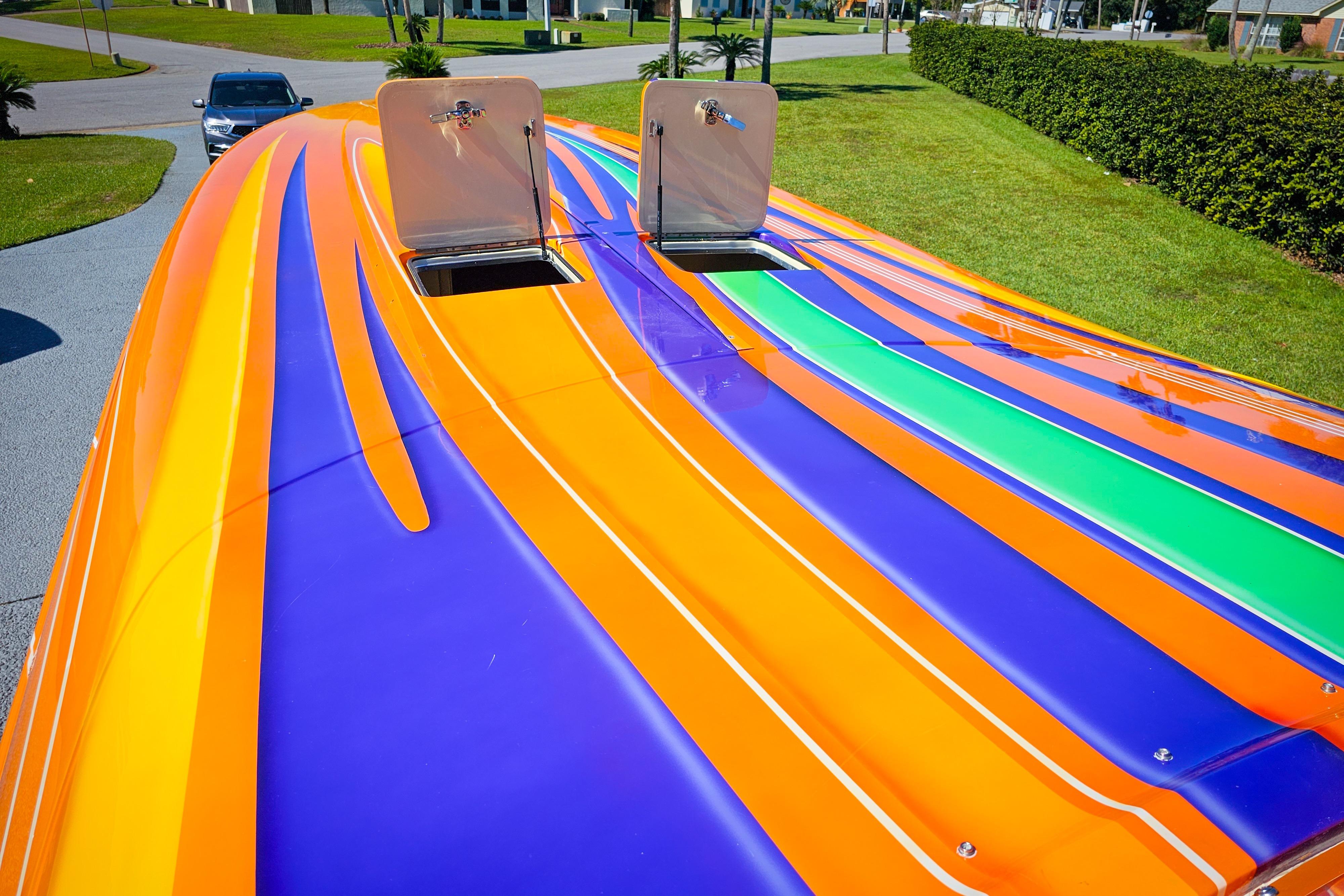 Colorful 2005 Outerlimits 51 Sport Yacht with vibrant orange, purple, and green stripes.