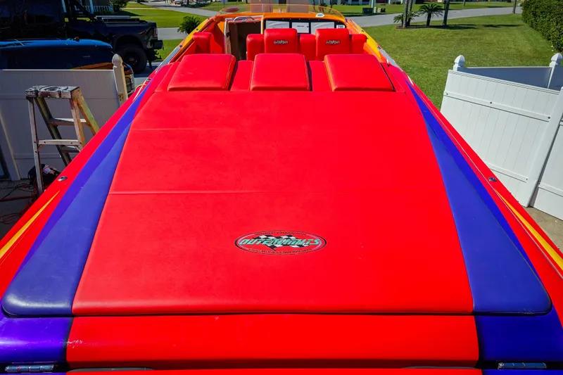  Yacht Photos Pics 2005 Outerlimits 51 Sport Yacht with vibrant red and blue upholstery, parked outdoors.