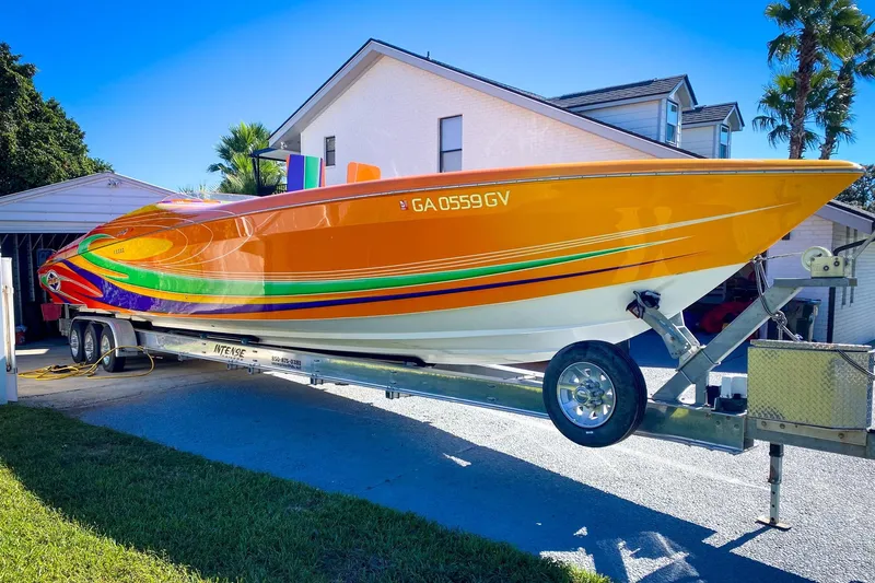  Yacht Photos Pics 2005 Outerlimits 51 Sport Yacht with vibrant orange and multicolor design on a trailer.