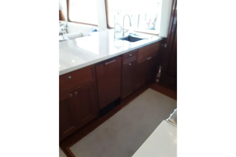 Endless Summer Yacht Photos Pics Luxurious kitchen area in 2008 Offshore Yachts 62 Flushdeck, featuring wooden cabinetry and modern sink.