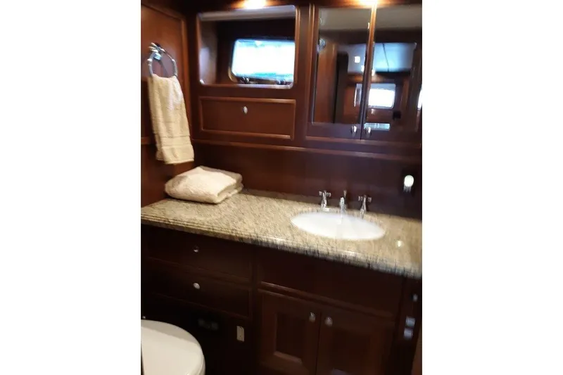 Endless Summer Yacht Photos Pics Luxurious bathroom in 2008 Offshore Yachts 62 Flushdeck with granite countertop and wooden cabinetry.