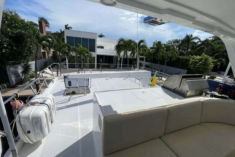 Endless Summer Yacht Photos Pics 2008 Offshore Yachts 62 Flushdeck with spacious deck, outdoor seating, and grill, docked near modern home.