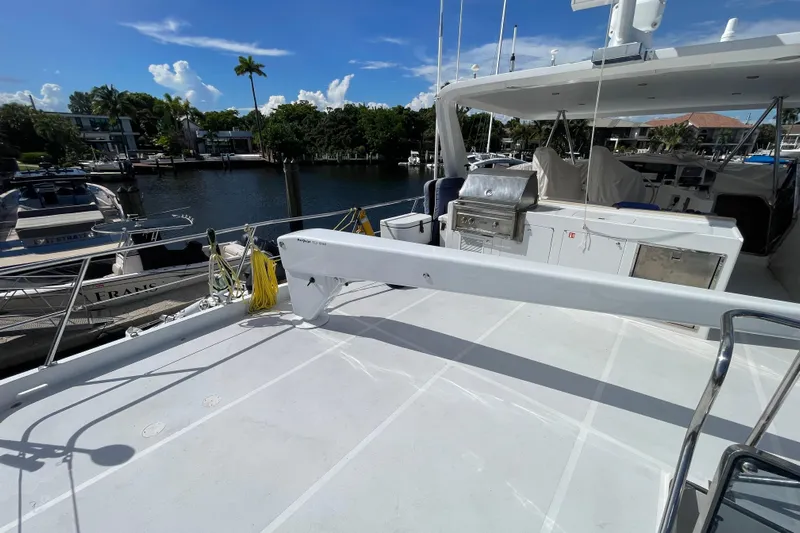 Endless Summer Yacht Photos Pics 2008 Offshore Yachts 62 Flushdeck, spacious deck with grill, docked by waterfront homes.