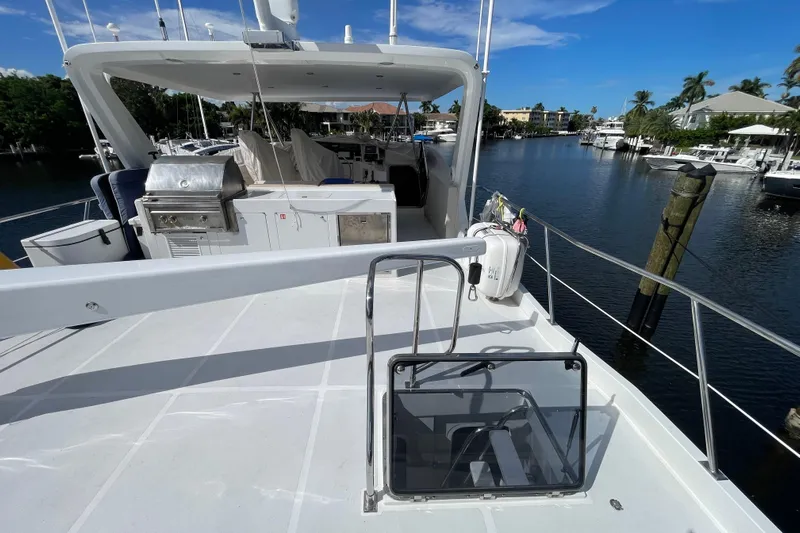 Endless Summer Yacht Photos Pics 2008 Offshore Yachts 62 Flushdeck, spacious deck with grill, docked by a serene waterfront.