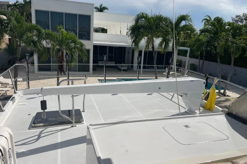 Endless Summer Yacht Photos Pics 2008 Offshore Yachts 62 Flushdeck, docked near modern house with palm trees.