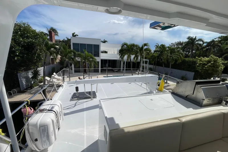 Endless Summer Yacht Photos Pics 2008 Offshore Yachts 62 Flushdeck, docked near a modern house with palm trees.