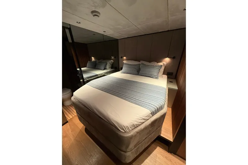 Serenity Yacht Photos Pics Luxurious bedroom interior of 2024 Sunreef 60 yacht with elegant bedding and ambient lighting.