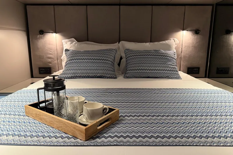 Serenity Yacht Photos Pics Luxurious Sunreef 60 yacht bedroom with elegant bedding and coffee tray, 2024 model.