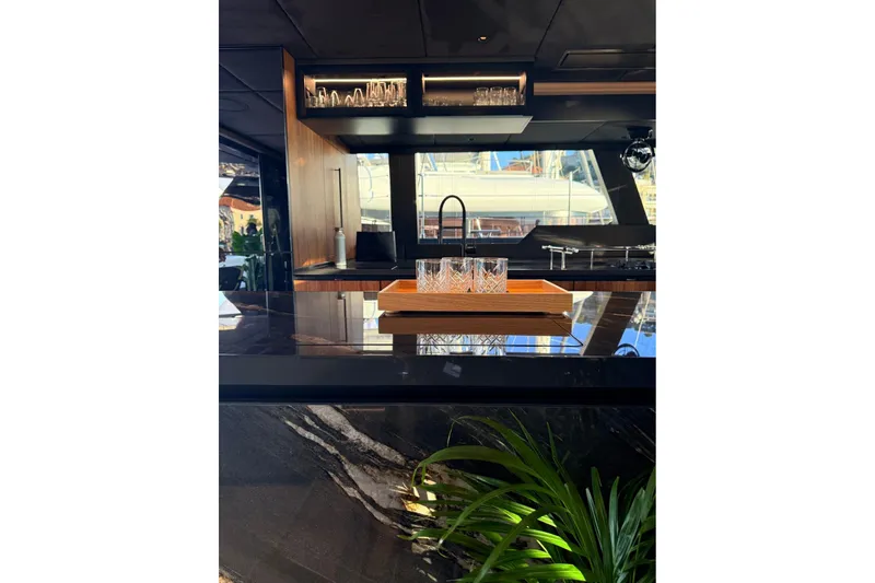 Serenity Yacht Photos Pics Luxurious interior of 2024 Sunreef 60 yacht with elegant bar and glassware.