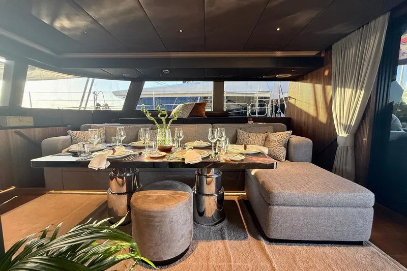 Serenity Yacht Photos Pics Luxurious interior of 2024 Sunreef 60 yacht with elegant dining setup and modern decor.