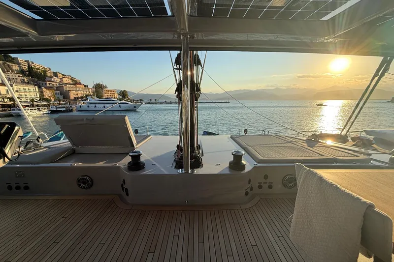 Serenity Yacht Photos Pics Luxurious 2024 Sunreef 60 yacht deck at sunset, overlooking serene coastal waters.