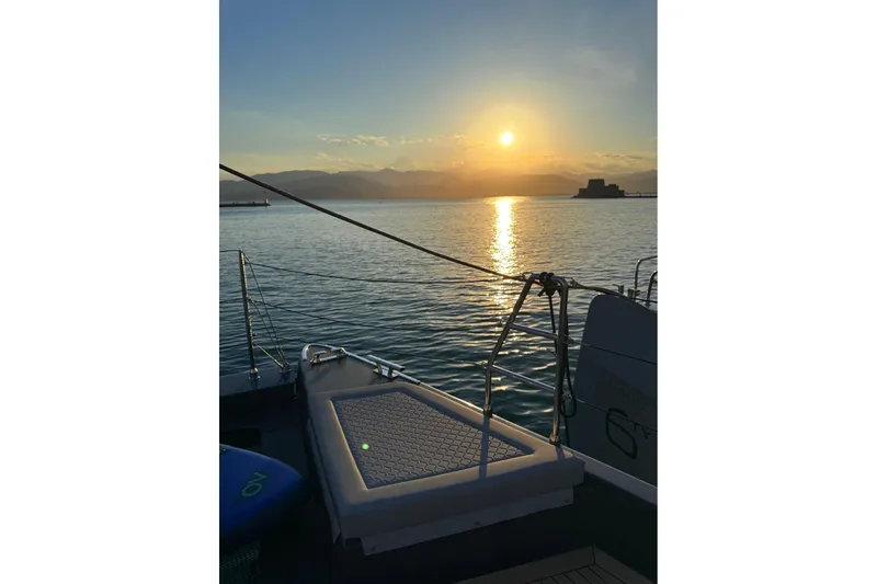 Serenity Yacht Photos Pics Sunset view from a 2024 Sunreef 60 yacht, overlooking calm waters and distant mountains.