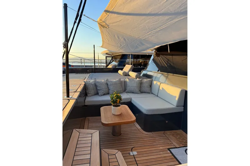 Serenity Yacht Photos Pics Luxurious Sunreef 60 yacht deck with elegant seating, cushions, and table, 2024 model.