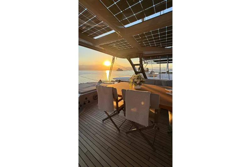 Serenity Yacht Photos Pics Luxurious Sunreef 60 yacht deck at sunset, 2024 model, with elegant seating and ocean view.