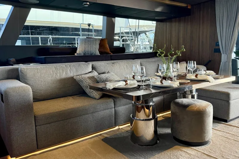 Serenity Yacht Photos Pics Luxurious interior of 2024 Sunreef 60 yacht with elegant dining setup and plush seating.