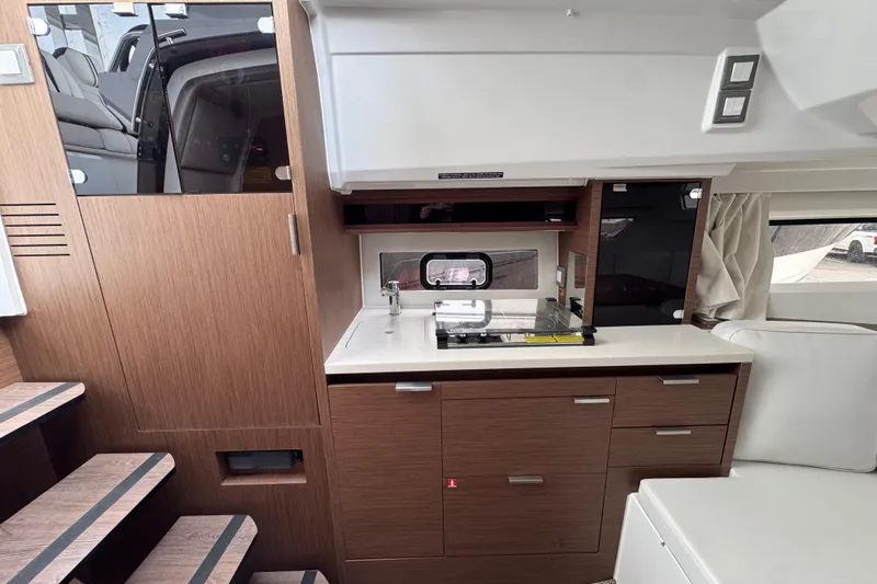  Yacht Photos Pics Interior of 2025 Jeanneau Leader 10.5 WA Series 2, featuring modern kitchenette and seating.