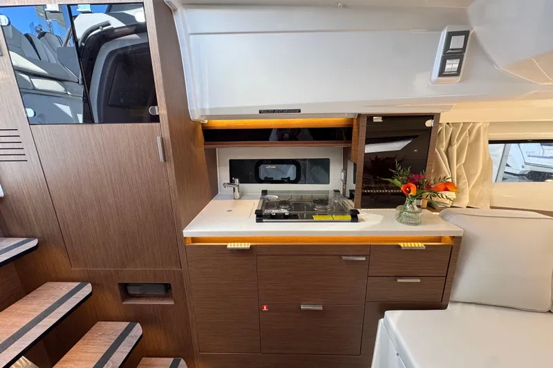  Yacht Photos Pics 2025 Jeanneau Leader 10.5 WA Series 2 interior kitchen with stove and floral decor.