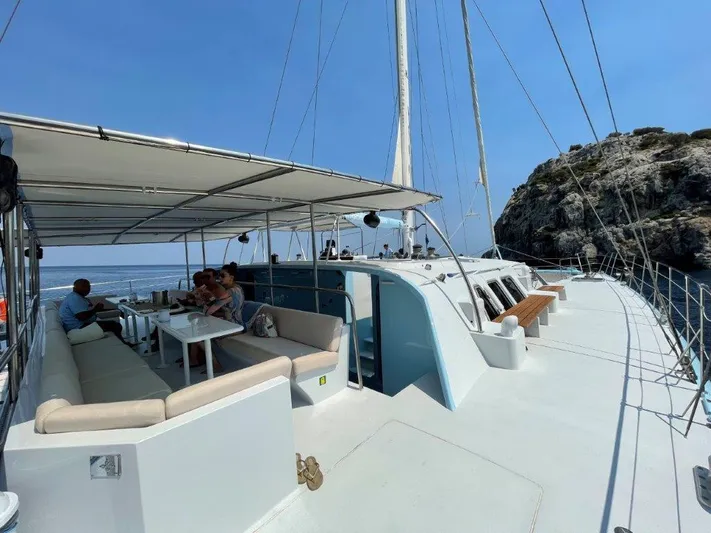 Ps 70 Yacht Photos Pics Luxurious 1990 Shuttleworth BLUE PEGASUS 70 yacht with passengers, sailing near rocky coastline.